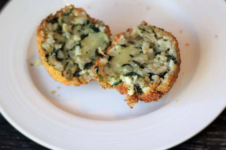 spinach and mozzarella variation of arancini cut open 