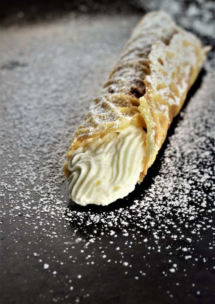 pizzelle cannoli with ricotta filling dusted with powdered sugar