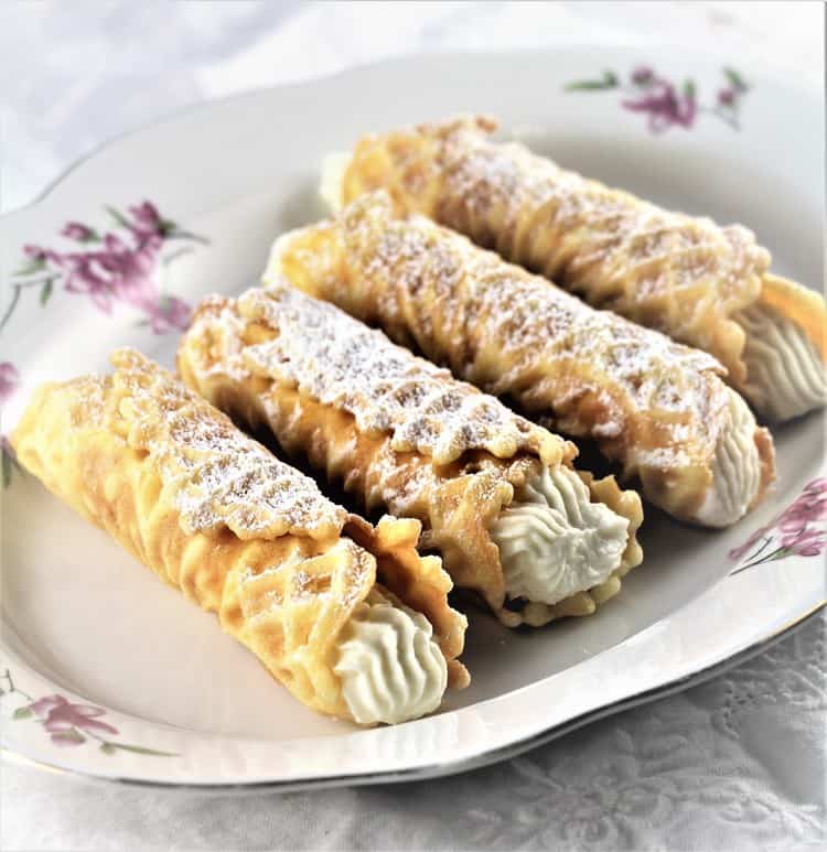 4 Pizzelle Cannoli with Ricotta Filling on white plate with flowers