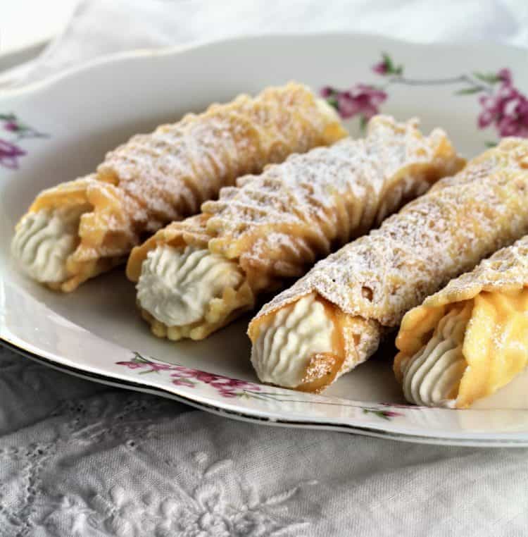 4 pizzelle cannoli filled with ricotta on a serving platter