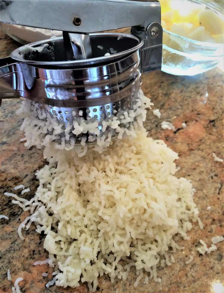 potato ricer ricing potatoes on a counter 