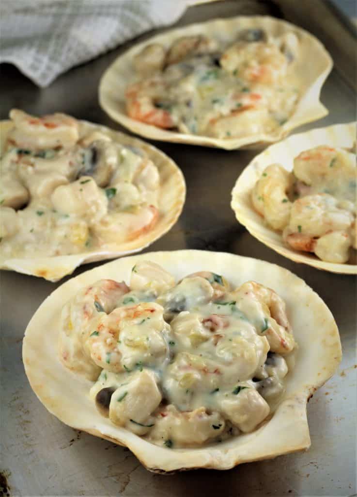 scallop shells filled with seafood and bechamel sauce mixture