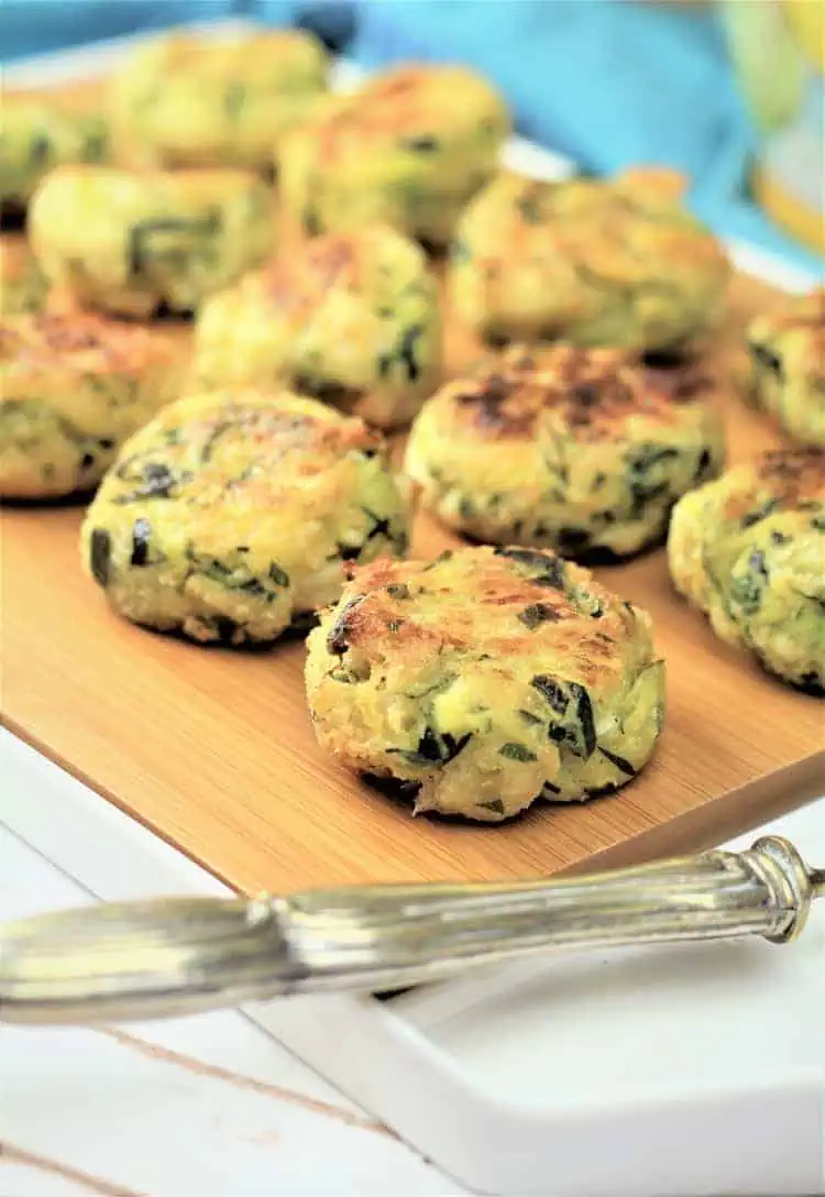 zucchini ricotta meatballs on wooden board with utensil