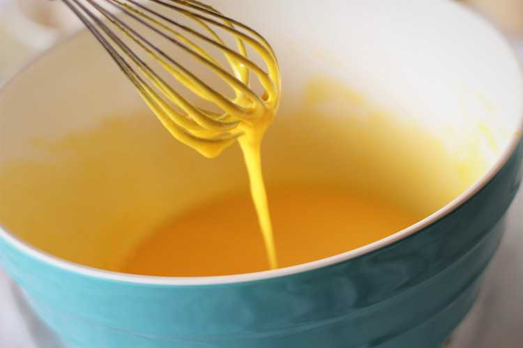 whisking eggs in mixing bowl with whisk for nonna's sponge cake