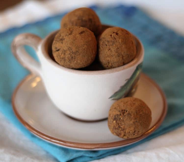 cocoa covered truffles in a coffee cup