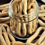 piles of white wine taralli in glass jar and around the jar