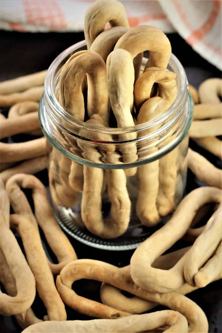 piles of white wine taralli in glass jar and around the jar