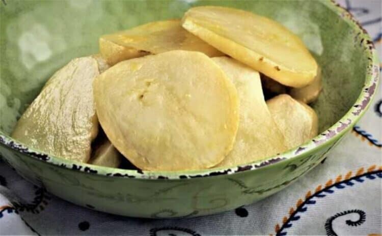 Thinly sliced golden baked potato slices in bowl.