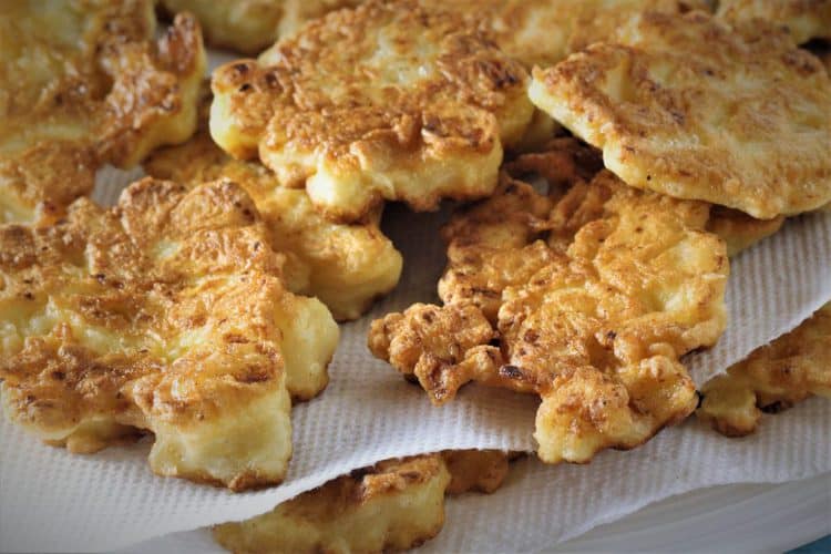 Cauliflower fritters on white plate covered in paper towels to absorb excess oil