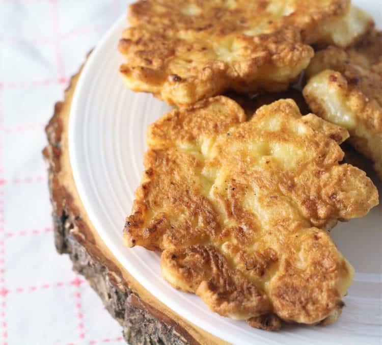 white plate with three cauliflower fritters