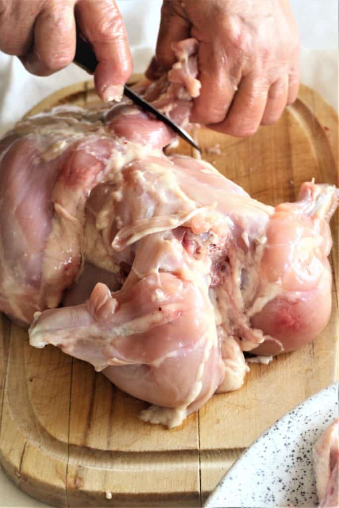 separating chicken flesh from with knife