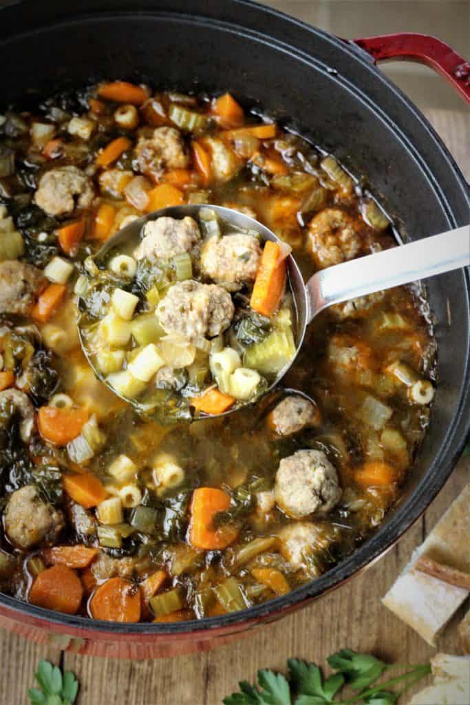 overhead view of meatball and vegetable soup being ladled 