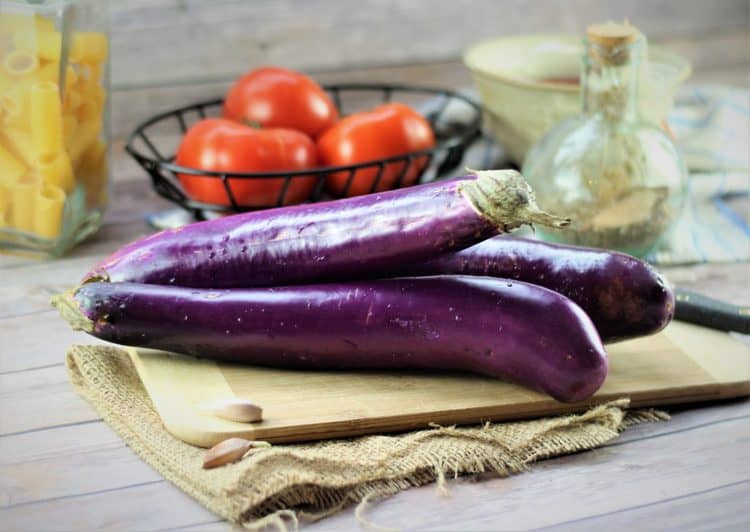 chinese eggplant, basket of tomatoes and jar with pasta 