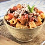 Sicilian pasta alla Norma (eggplant pasta) in bowl topped with ricotta salata.