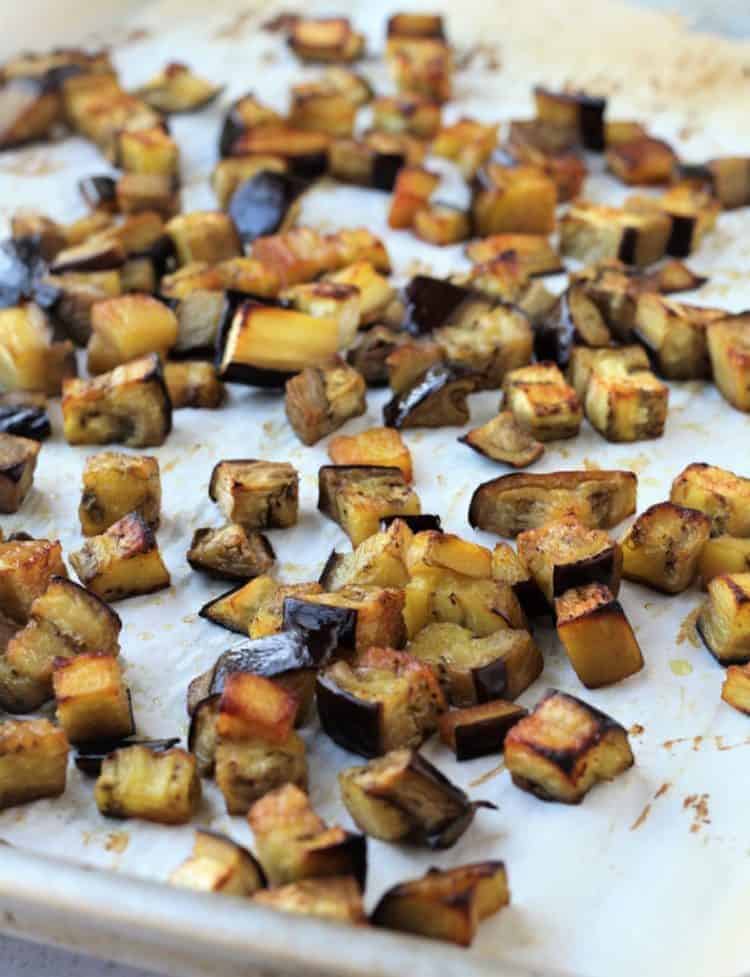 Roasted eggplant cubes on baking sheet for pasta alla Norma.