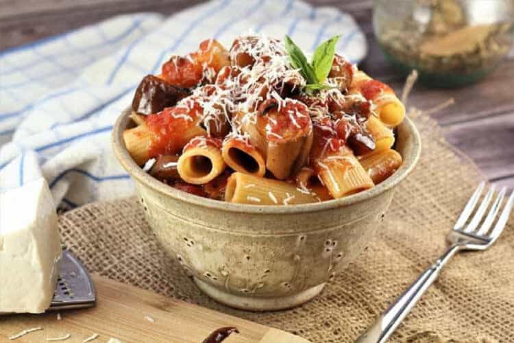 Pasta alla Norma in bowl topped with grated ricotta salata.