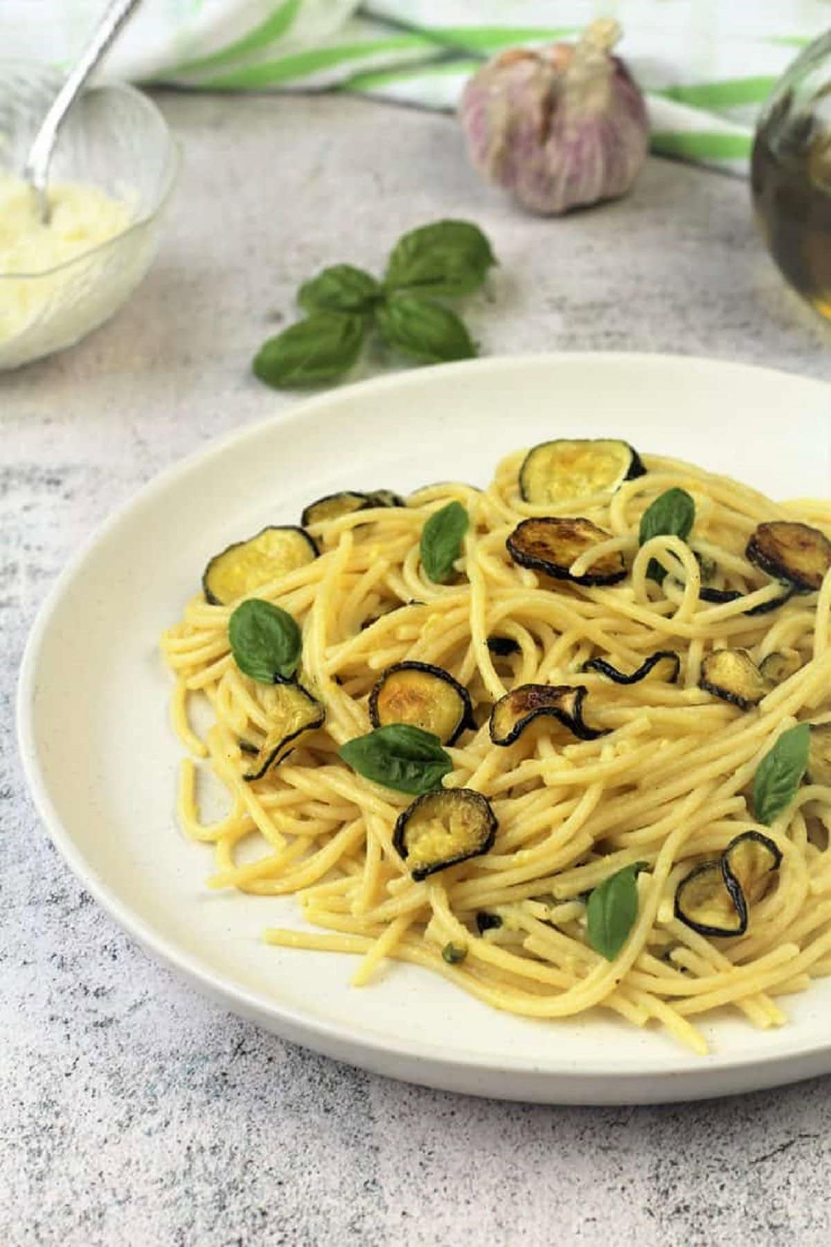 spaghetti-with-zucchini Spaghetti with fried zucchini on plate topped with basil leaves.