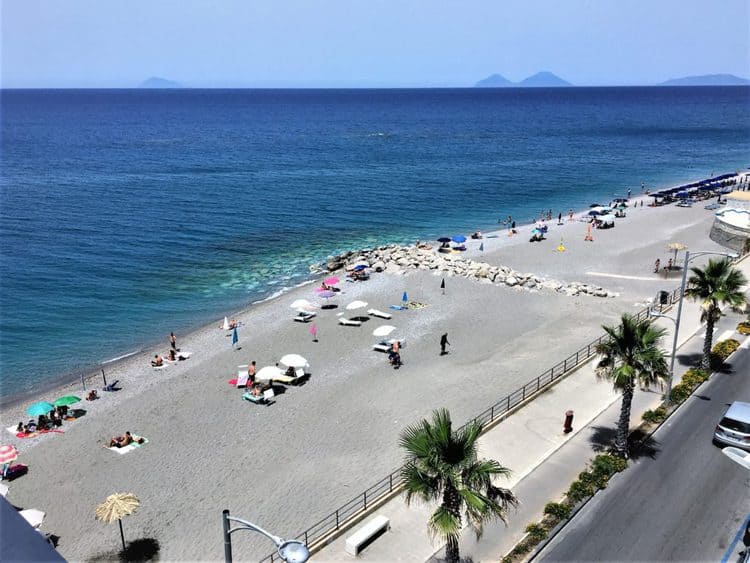 balcony view of a sandy beach with islands in the distance