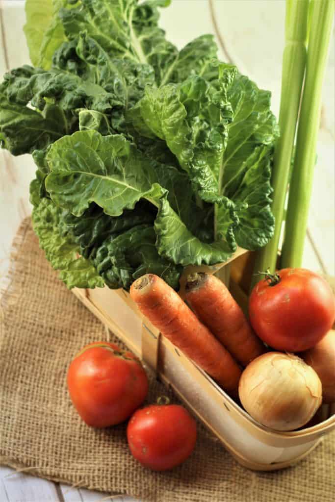 basket with swiss chard, carrots, tomatoes and onion