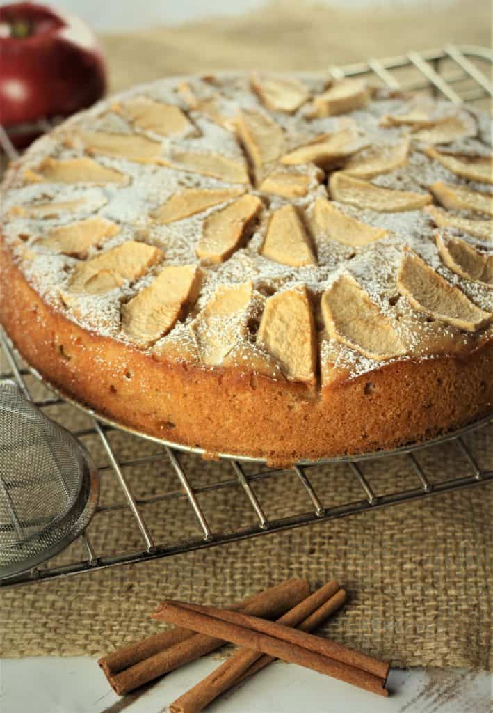 Italian Apple Yogurt Cake on wire rack with cinnamon sticks on side