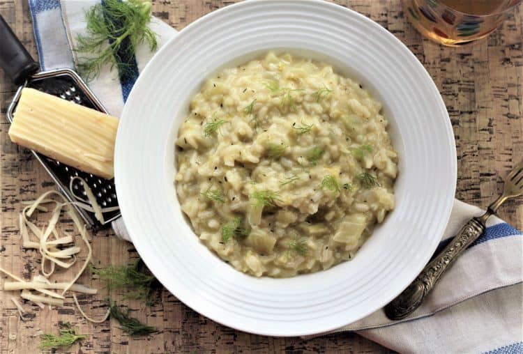 bowl of fennel and leek risotto with a cheese grater and cheese, fork