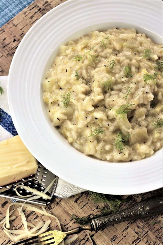 fennel risotto with leeks plated with fork and Parmigiano chunk 