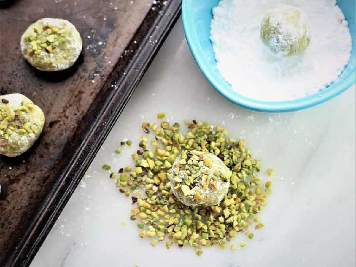 Amaretti cookies coated in powdered sugar and pistachios.