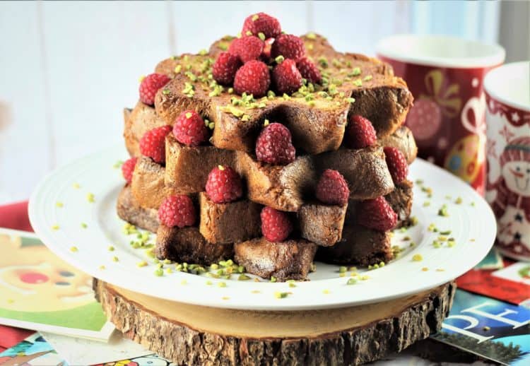 Pandoro french toast slices piled with raspberries and pistachios