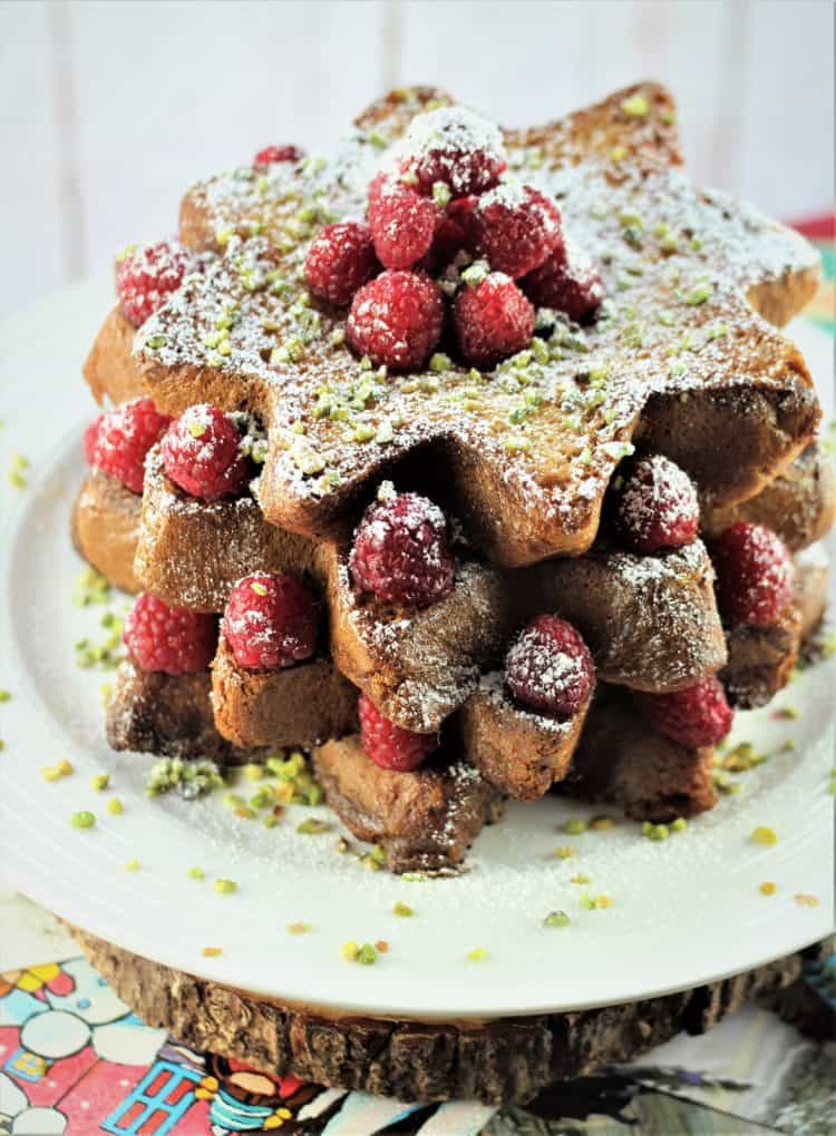 Pandoro french toast slices topped with raspberries, pistachios and powdered sugar