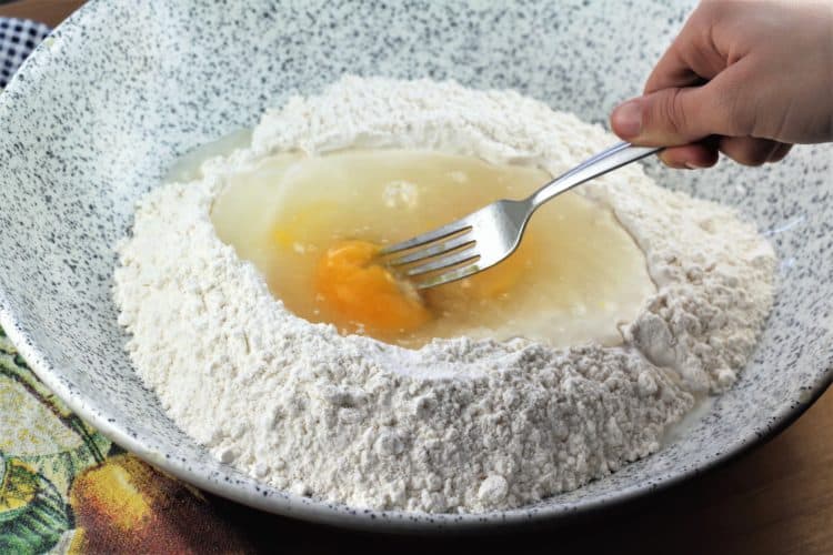 whisking eggs into flour for pasta 
