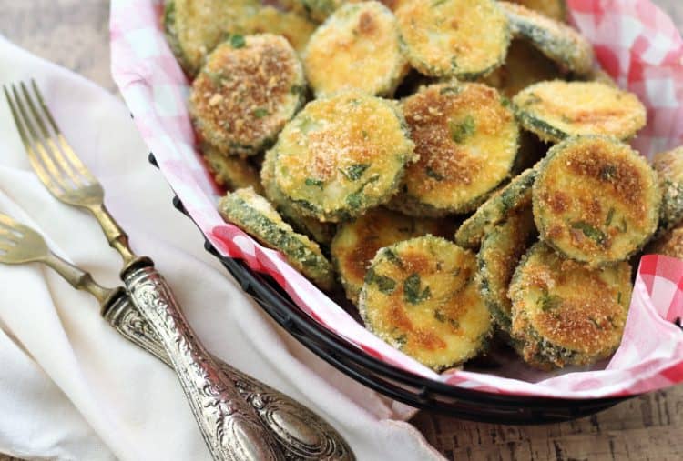 close up of a basket full of zucchini crisps with forks on the side