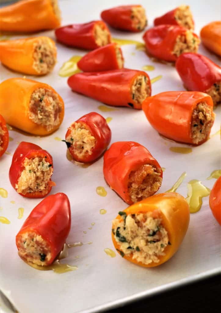 baking sheet with stuffed mini peppers drizzled in olive oil