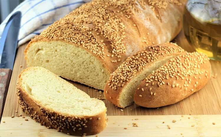 semolina bread sliced with olive oil bottle in back ground