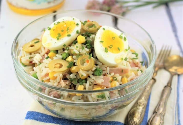 glass bowl filled with rice salad topped with hard boiled egg halves