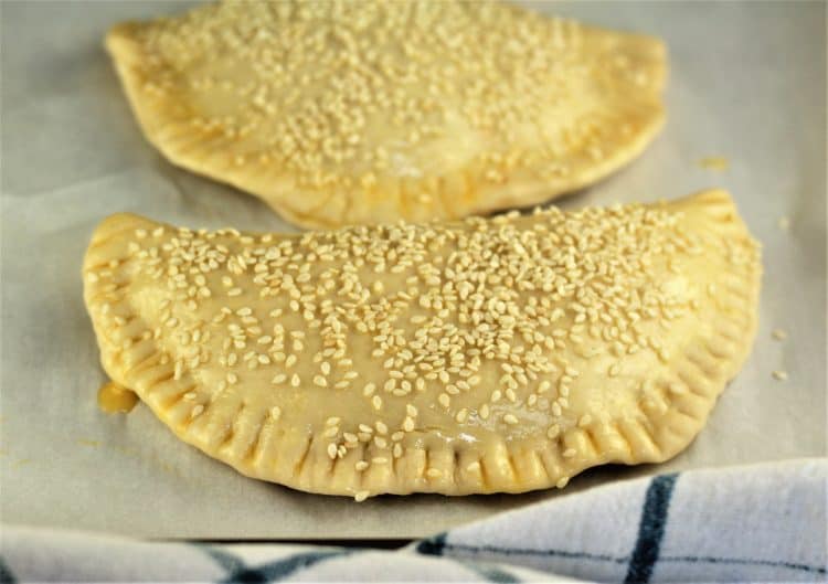 calzone covered in egg wash in sesame seeds prior to baking