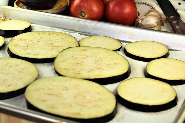 sliced eggplant rounds on baking sheet