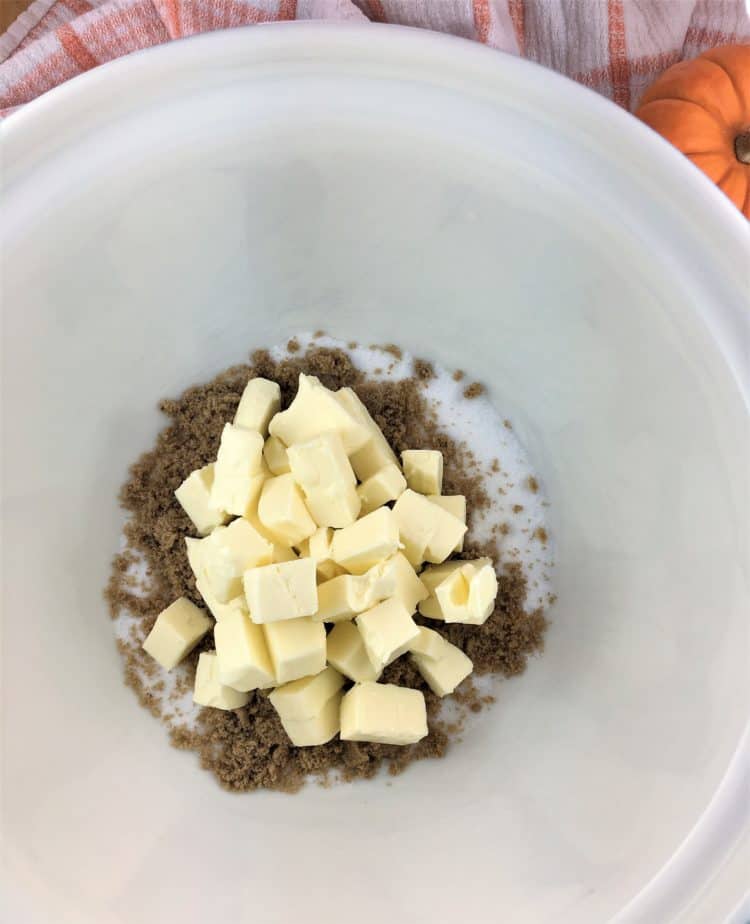mixing bowl filled with cubed butter and sugars