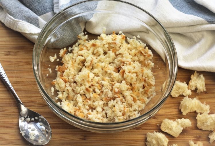 fresh bread crumbs soaked in milk in glass bowl with spoon on side