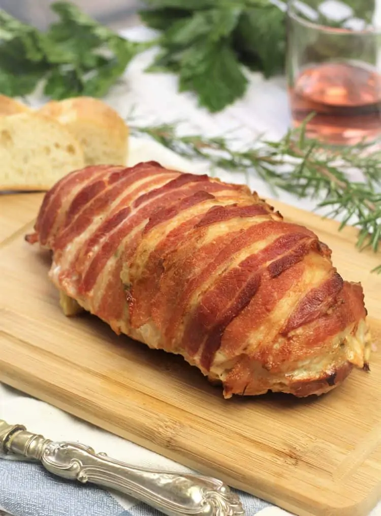 whole bacon covered turkey roast on wood board