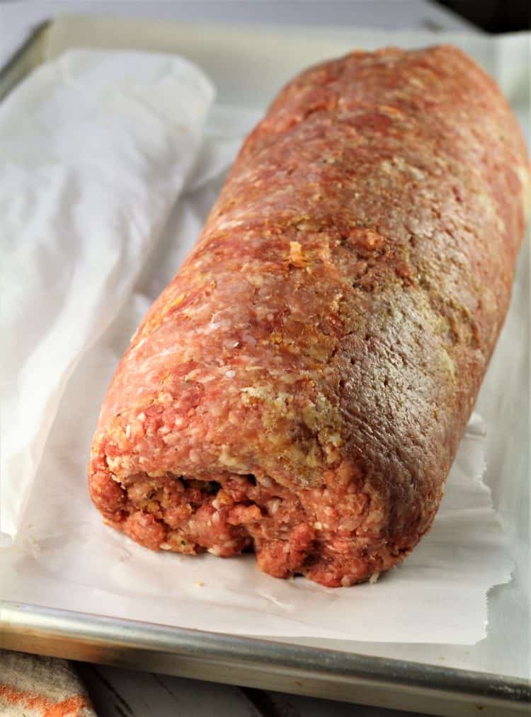 rolled pinwheel meatloaf on parchment paper on baking sheet 