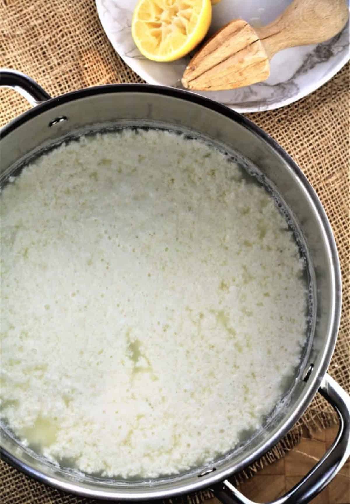 Curds and whey (ricotta) in sauce pan.