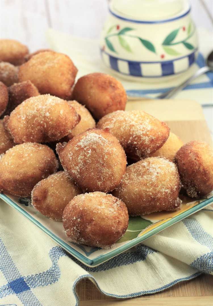 plate filled with potato sfinci and sugar bowl in background