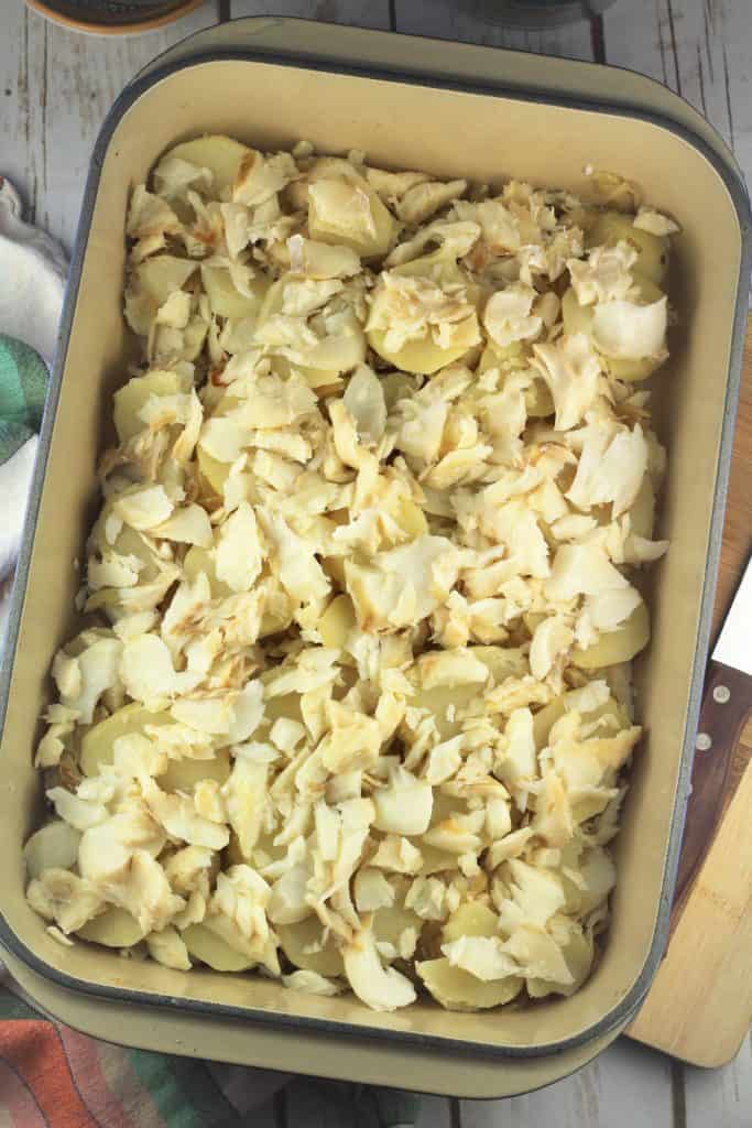 rectangular casserole dish covered with bite size cod pieces
