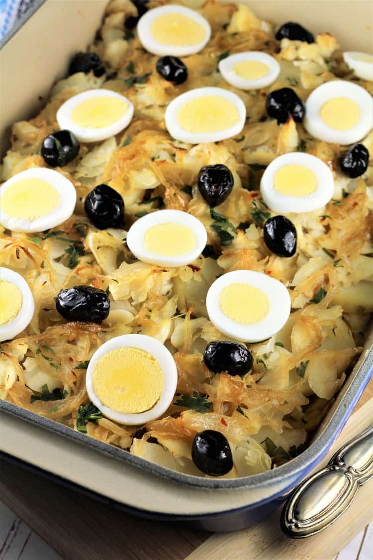 salt cod and potato casserole topped with hard boiled egg slices and black olives