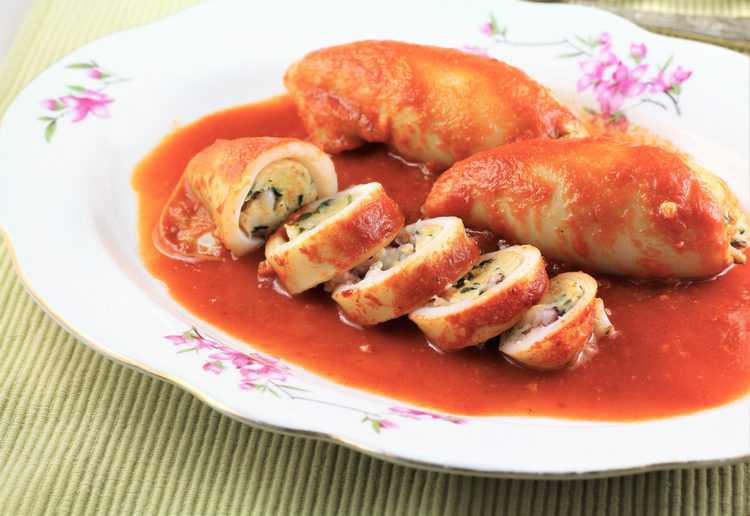 oval plate filled with sliced stuffed calamari on tomato sauce