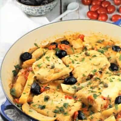 blue skillet with salt cod, potatoes, tomatoes and black olives