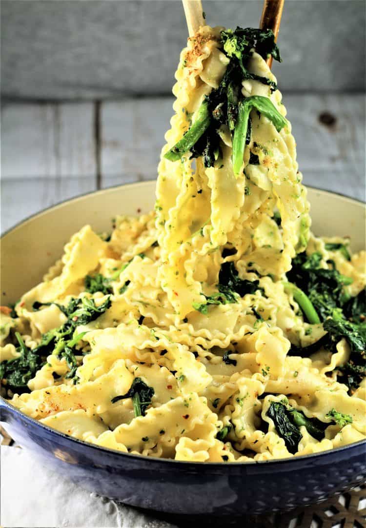 serving a large scoop of pasta with rapini from blue skillet