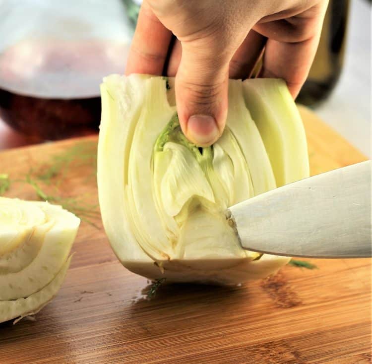 slicing off the core of a halved fennel bulb with knife