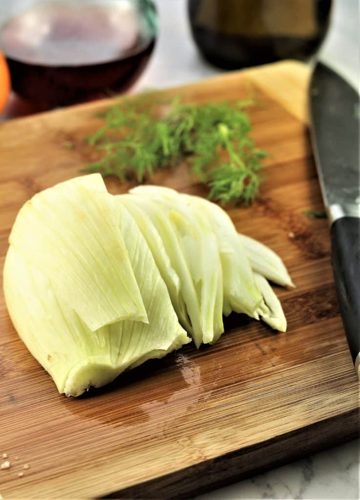 slicing fennel bulb into thin slices with knife 