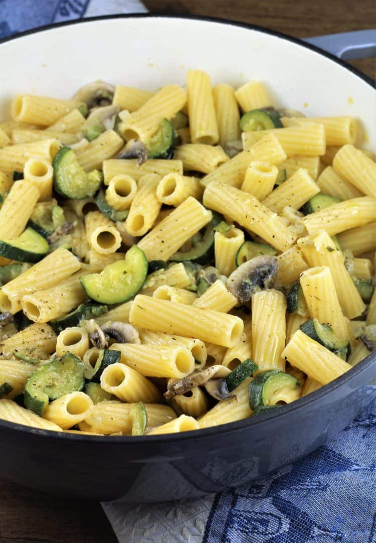 grey skillet filled with zucchini mushroom pasta